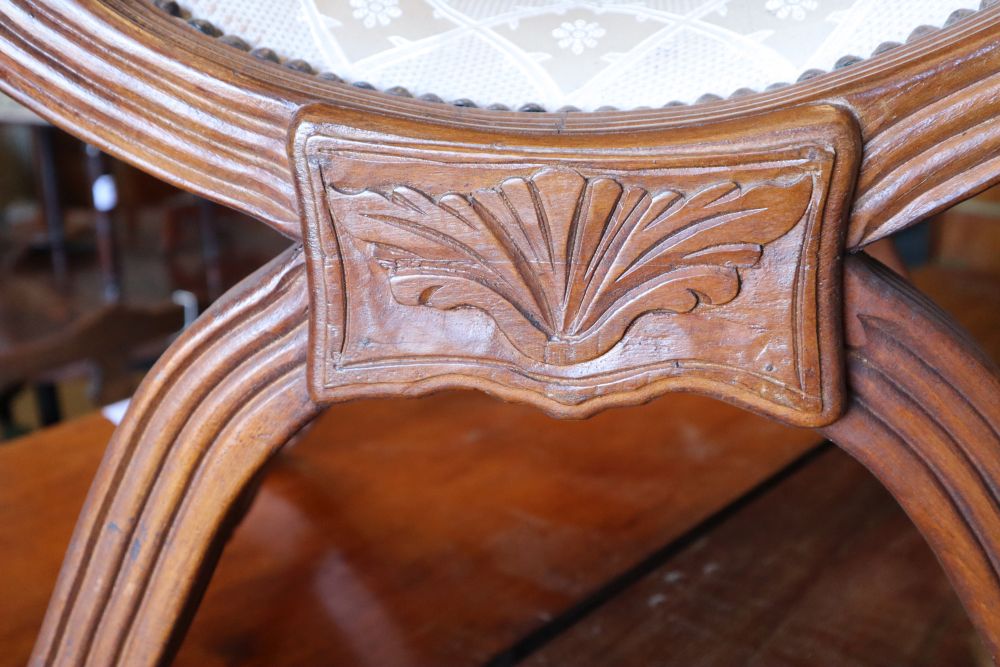 An early 20th century Anglo Burmese teak X frame stool, width 74cm